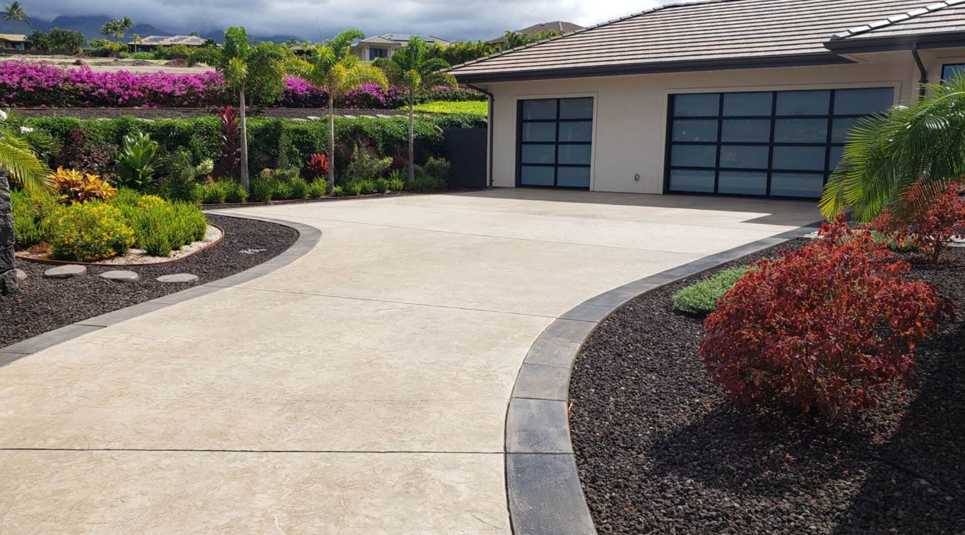Professional driveway installation with decorative concrete and landscaping